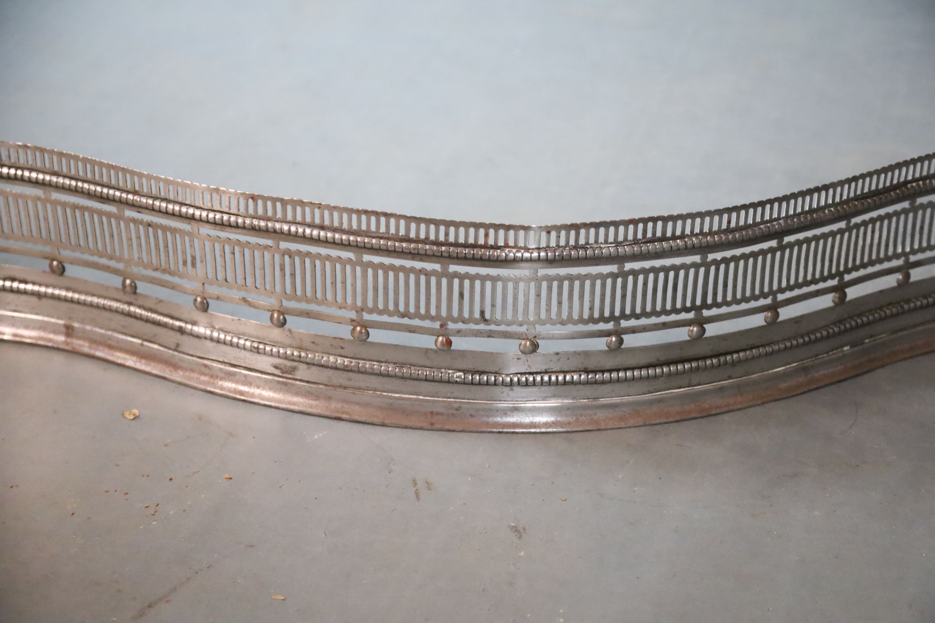 A George III style polished steel serpentine fender, W.107cm